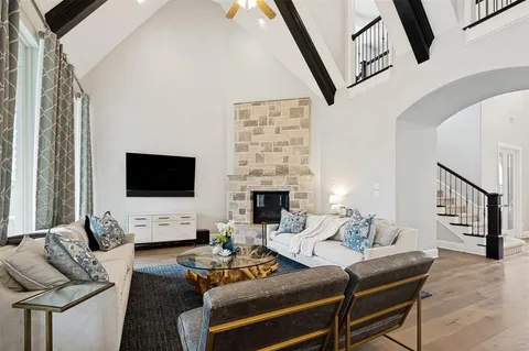 a living room with furniture a flat screen tv and a fireplace