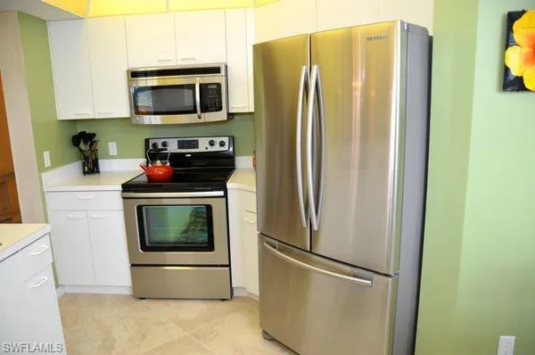 a kitchen with a refrigerator and a stove top oven