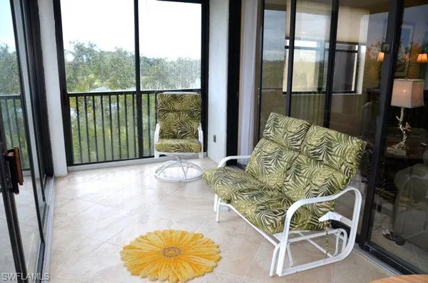 a living room with furniture and a floor to ceiling window
