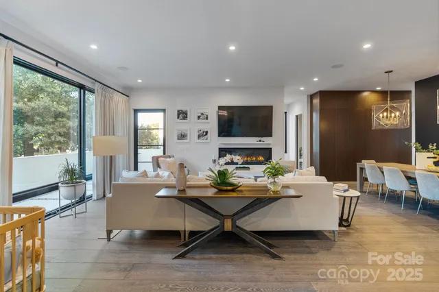 a living room with furniture a flat screen tv and a large window