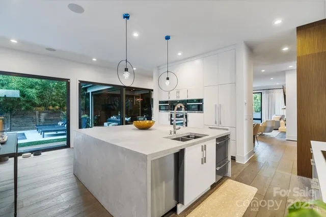 a view of counter top space with stainless steel appliances granite countertop a barbecue grill and a wooden floors