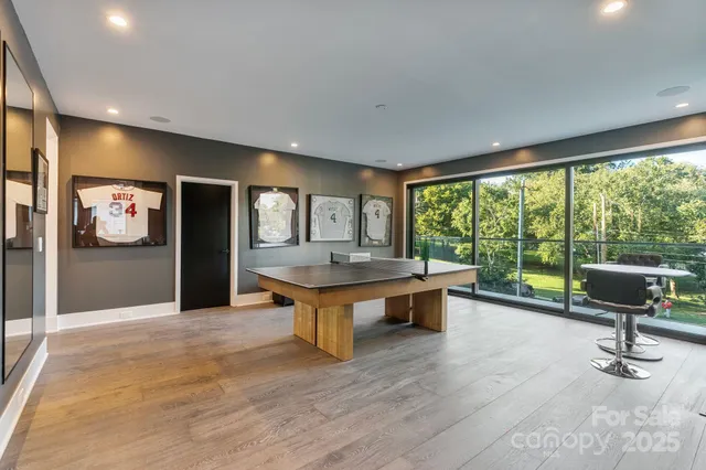 a living room with furniture pool table and a large window