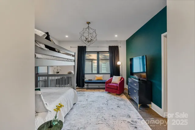 a bedroom with furniture and a large window