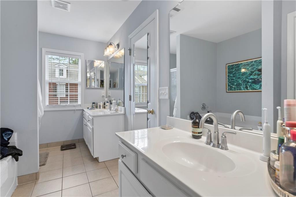 2924 Wintercrest Way Atlanta, GA 30360 - Photo 18 of 36 a bathroom with a granite countertop sink a mirror and a shower