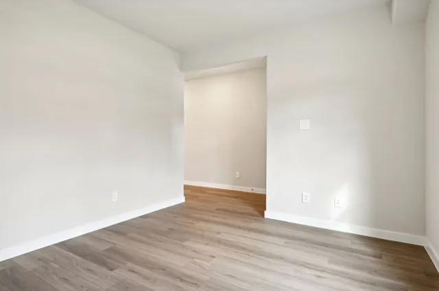 a view of an empty room with wooden floor