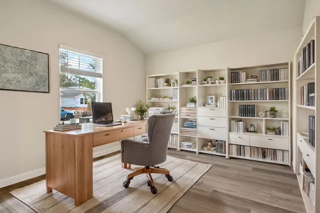 a view of a workspace with furniture and a bookshelf