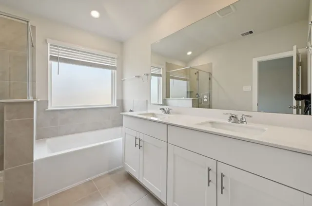 a bathroom with a tub sink and mirror