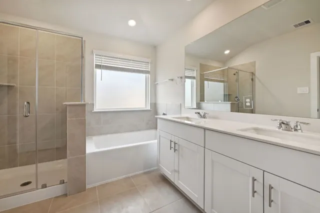 a bathroom with a tub sink shower and mirror