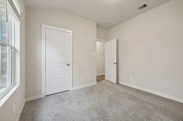 an empty room with windows and closet