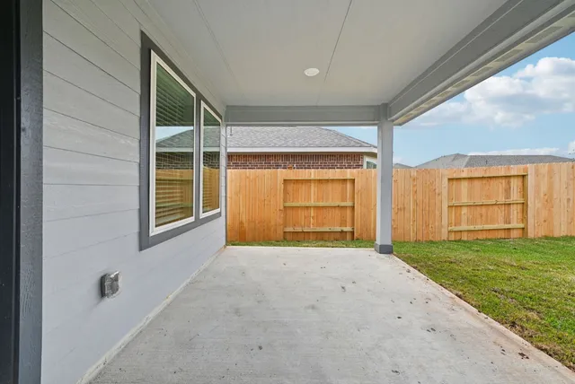 a view of an empty room with window and brick walls