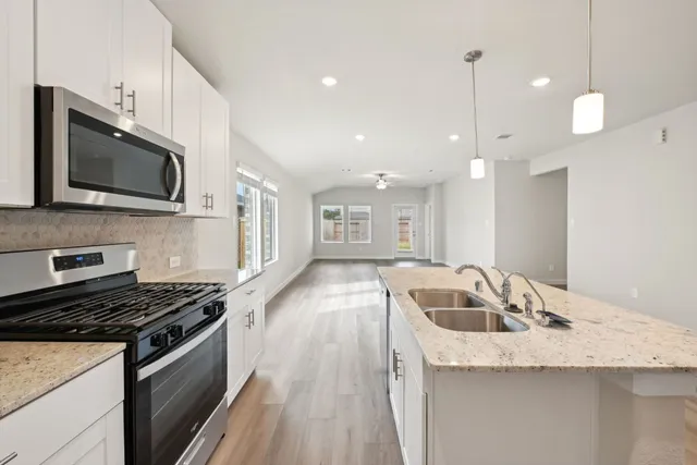 a kitchen with granite countertop a sink and stove top oven