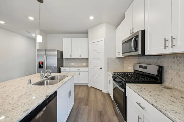 a kitchen with stainless steel appliances granite countertop a sink stove and cabinets