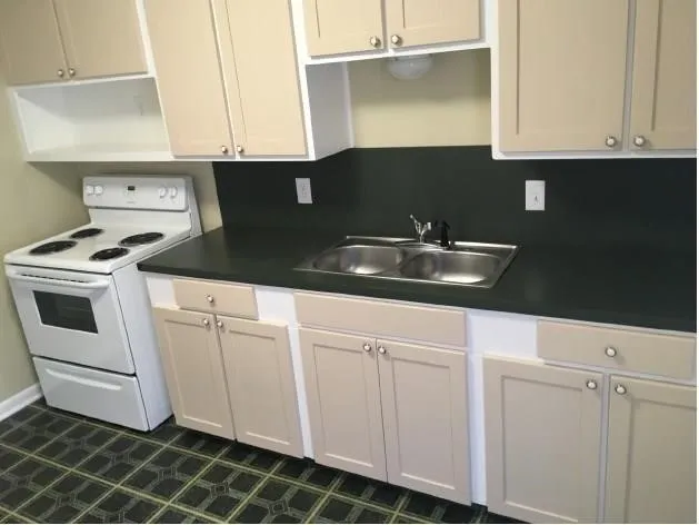 a kitchen with white cabinets and sink
