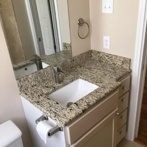a kitchen with a granite countertop sink and a mirror