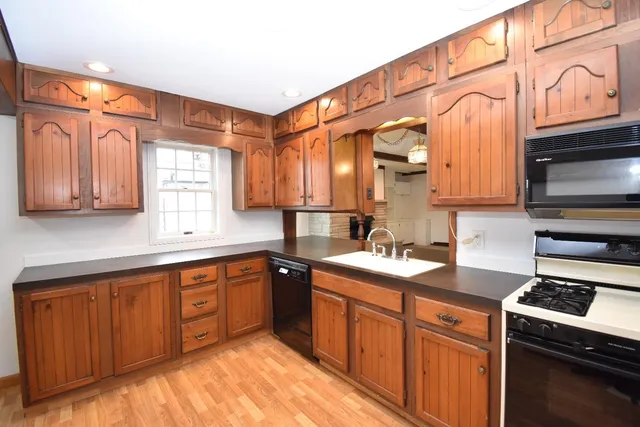 a kitchen with stainless steel appliances granite countertop a sink a stove and cabinets