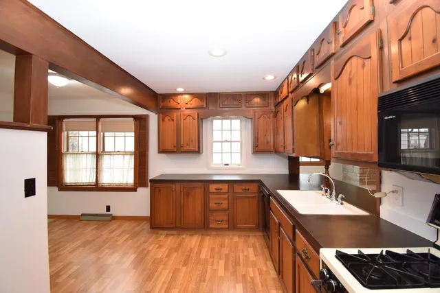 a kitchen with stainless steel appliances granite countertop a sink stove and cabinets