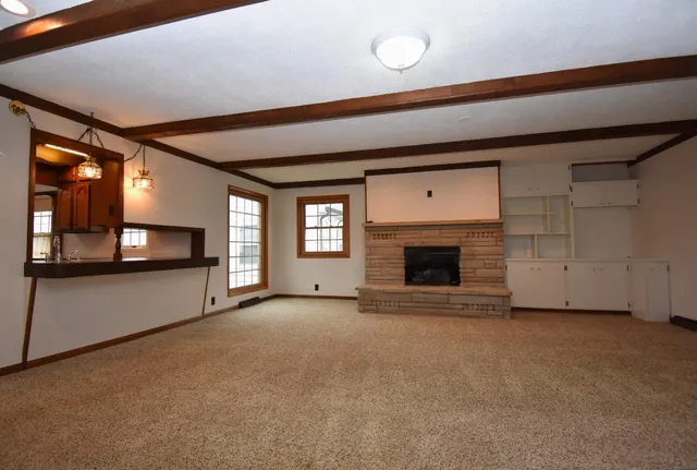 a view of an empty room with a fireplace and a window
