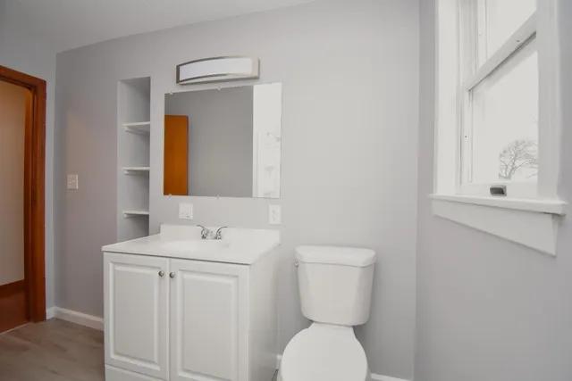 a bathroom with a toilet sink and mirror