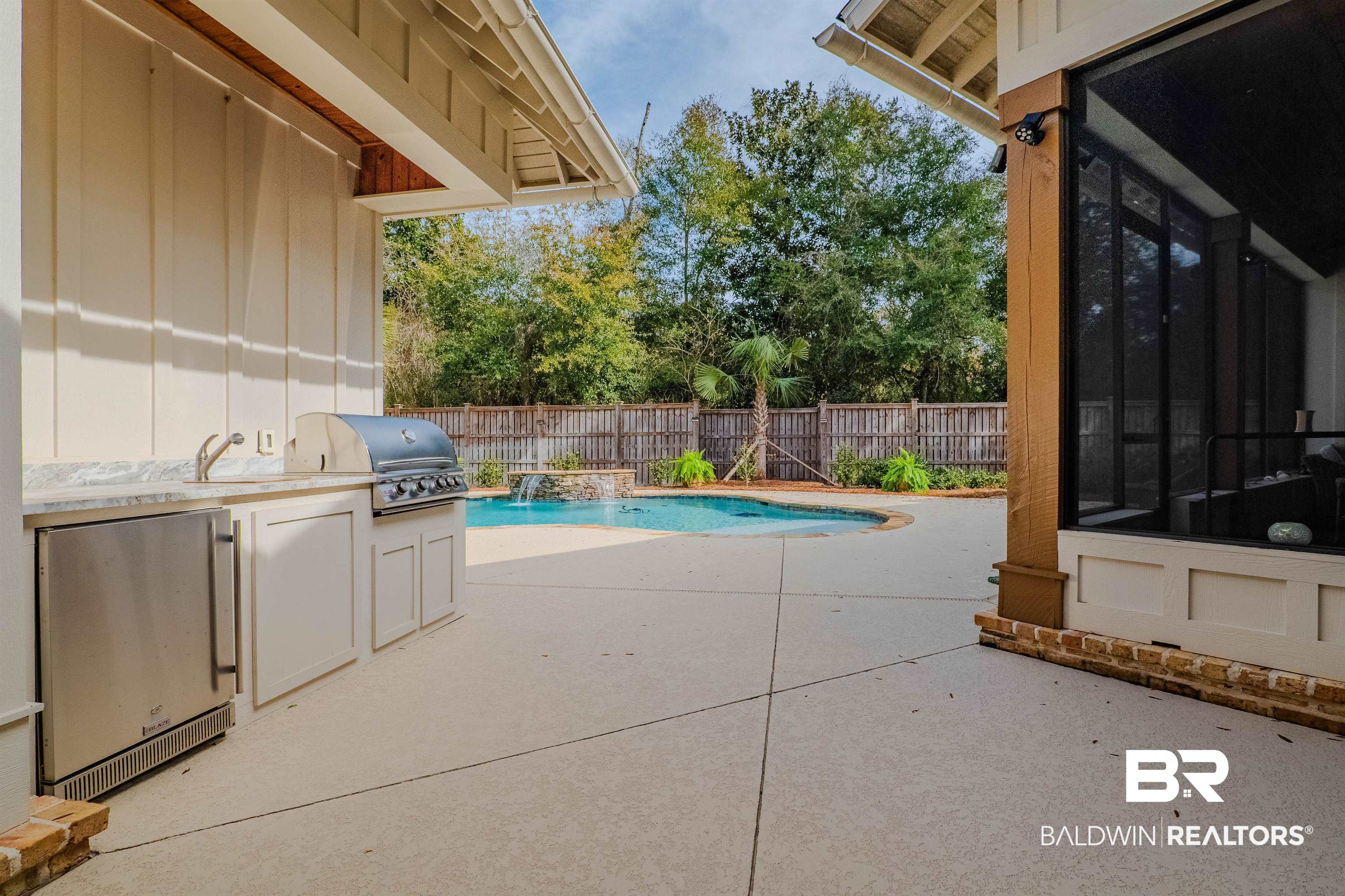 708 Manning Place Fairhope, AL 36532 - Photo 46 of 58 View of swimming pool featuring a grill, a sunroom, a patio, and an outdoor kitchen