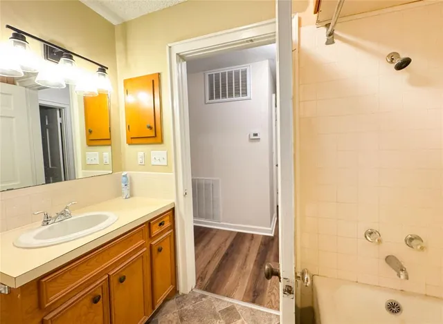 a bathroom with a tub sink and mirror