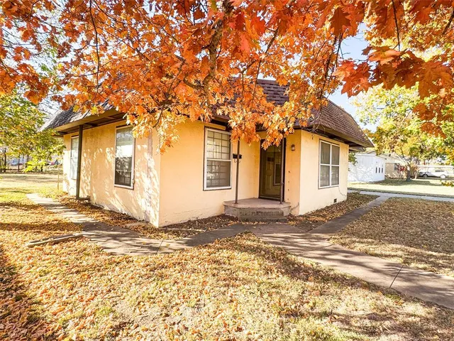 a view of a house with a yard and road