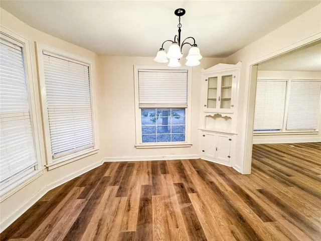 a view of empty room with wooden floor and windows