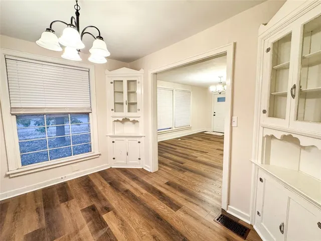 a view of empty room with wooden floor and windows