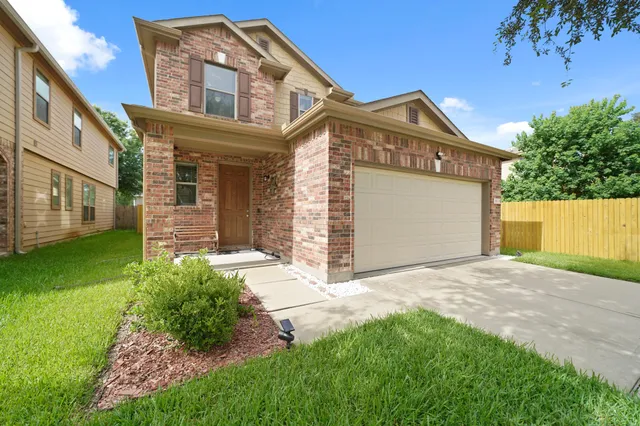 a front view of a house with a garden and yard