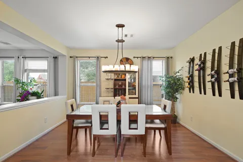 a dining room with furniture a chandelier and wooden floor
