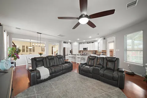 a living room with furniture ceiling fan and a window