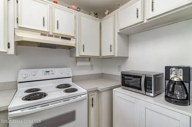 a kitchen with a stove and white cabinets
