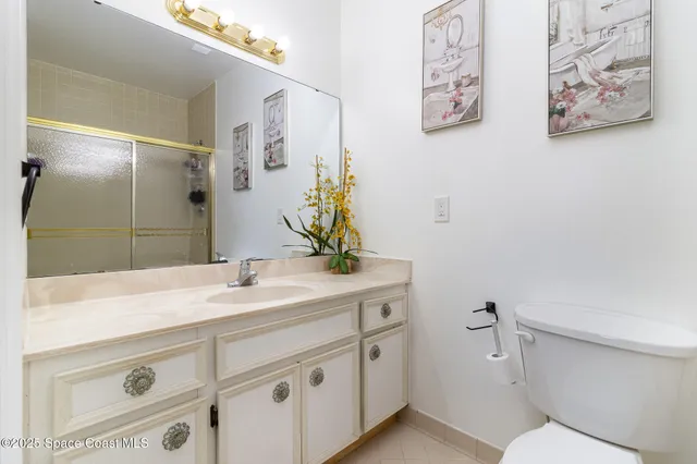 a bathroom with a granite countertop sink mirror vanity and toilet