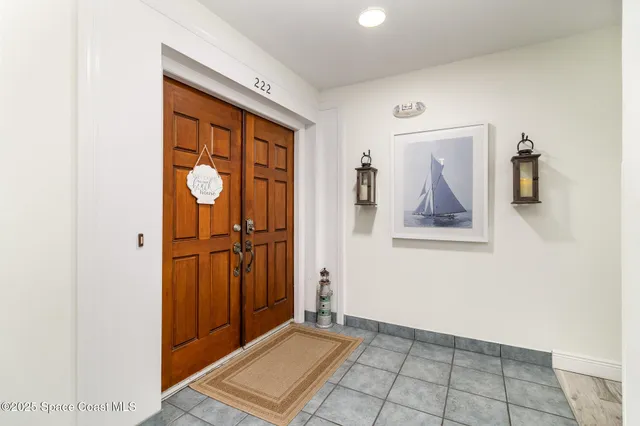 a view of a hallway with wooden floor and a bathroom