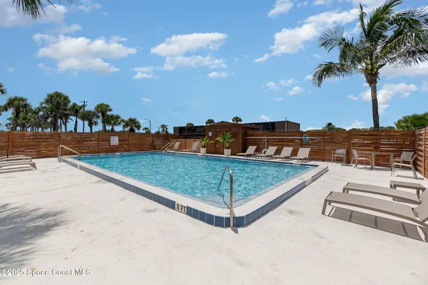 a view of a tennis ground with large trees