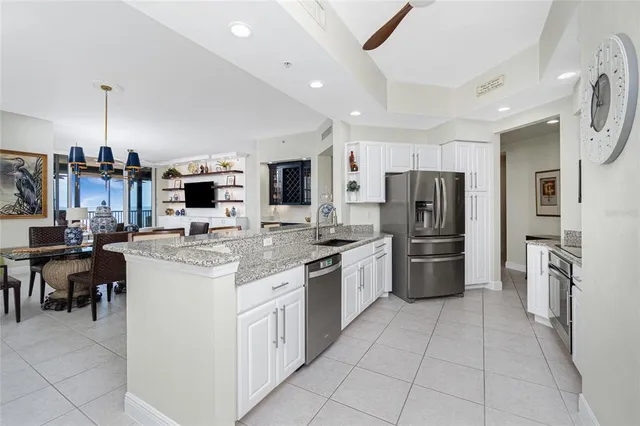a kitchen with a sink dishwasher a stove and white cabinets with wooden floor