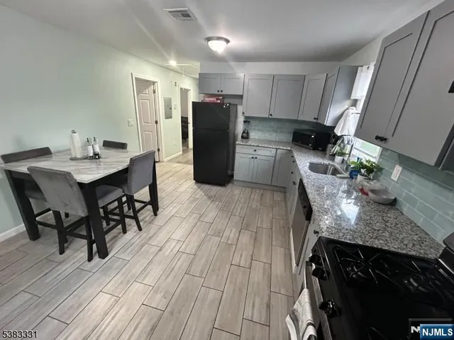 a kitchen with stainless steel appliances granite countertop a stove refrigerator and cabinets