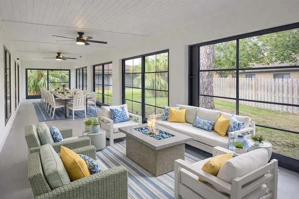 a living room with furniture and floor to ceiling windows