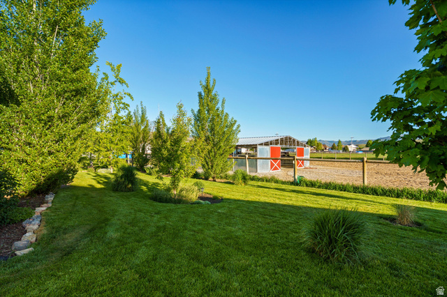 681 Island Road Morgan, UT 84050 - Photo 31 of 49 Expansive backyard featuring a manicured lawn, established trees, and natural stone landscaping