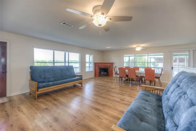 a living room with furniture a table and wooden floor
