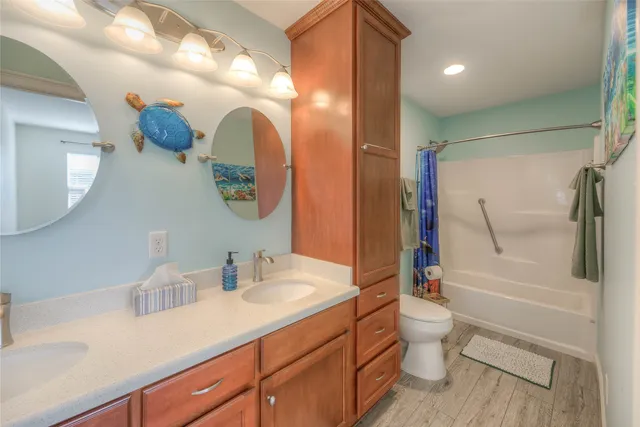 a bathroom with a double vanity sink toilet and shower