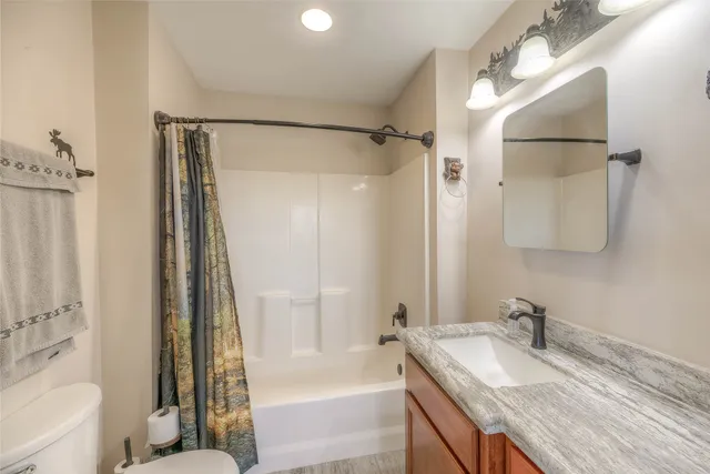 a bathroom with a granite countertop sink toilet and shower