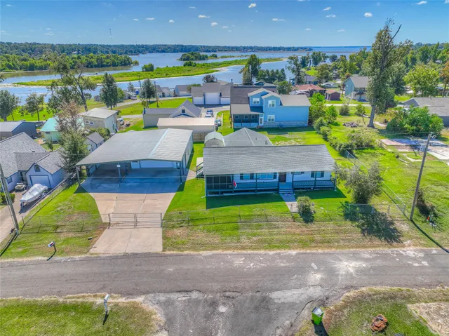 an aerial view of a swimming pool with a yard and outdoor seating