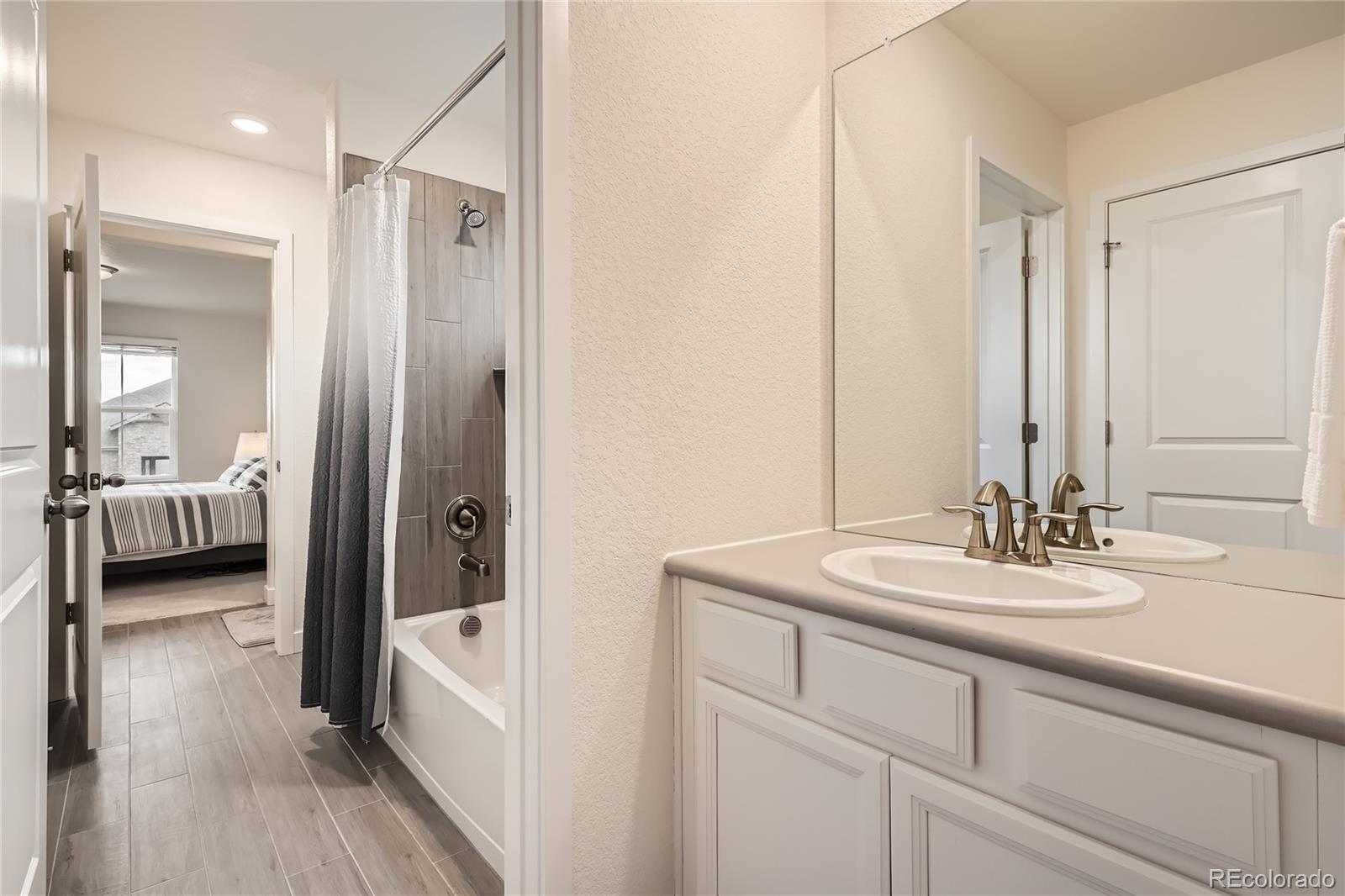 946 Compass Drive Erie, CO 80516 - Photo 19 of 28 a en suite bathroom with a double vanity sink and a mirror