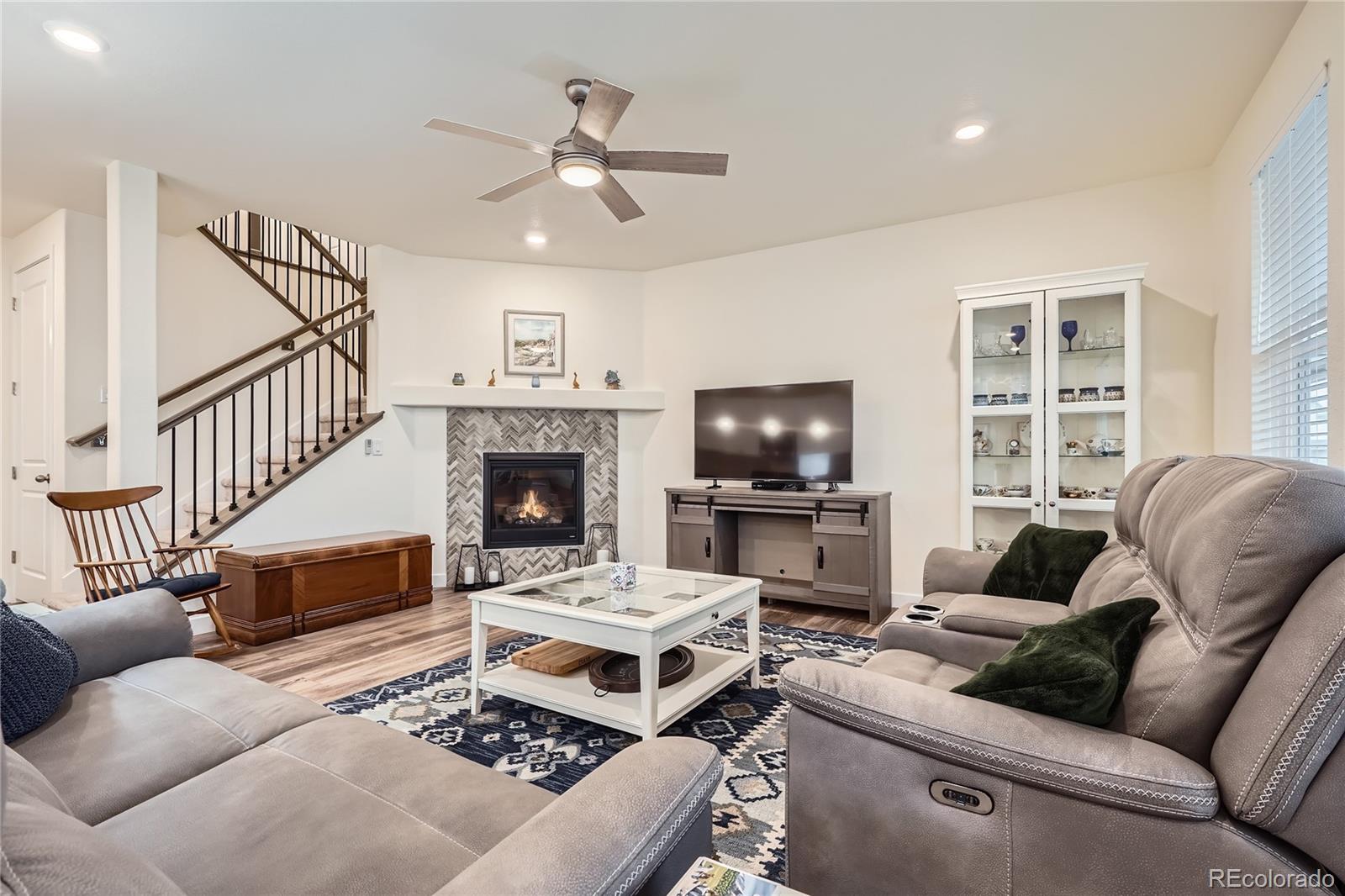 946 Compass Drive Erie, CO 80516 - Photo 10 of 28 a living room with furniture a flat screen tv and a fireplace