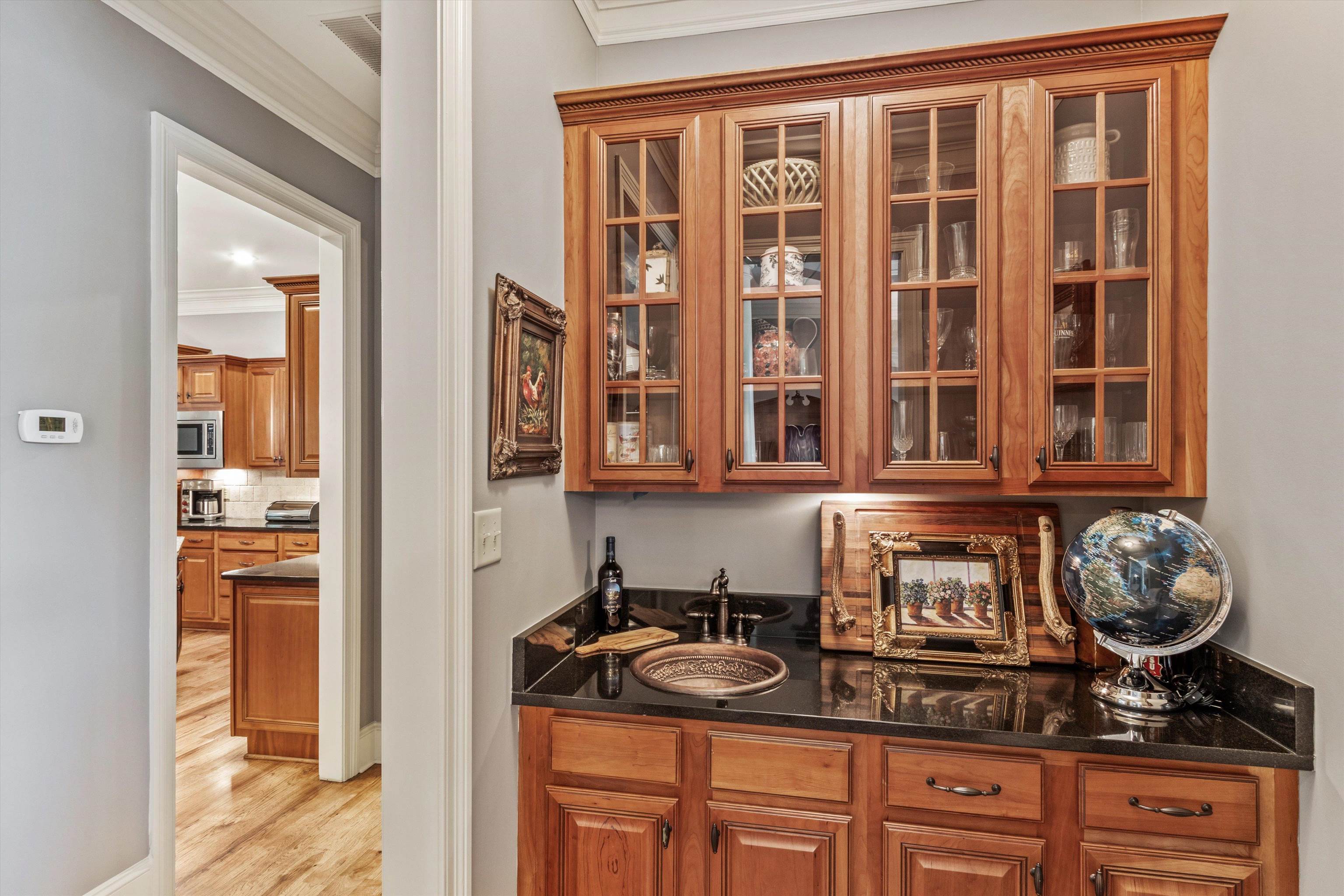 150 Ridgecrest Drive Arlington, TN 38002 - Photo 9 of 40 Built-in wet bar featuring custom wood cabinetry with glass fronts, dark stone countertop, and an undermount copper sink