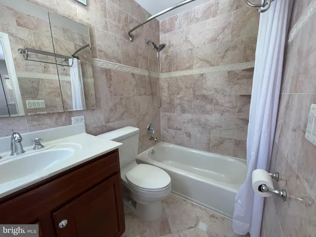 a view of an empty room with wooden floor and window