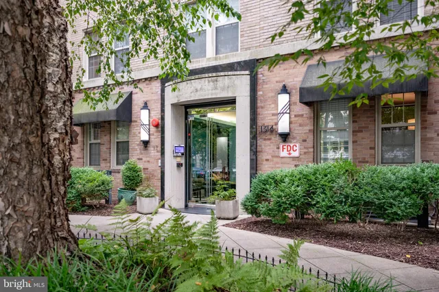 a view of a brick house with a large windows and plants