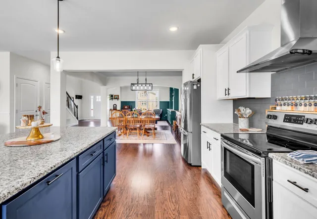 a kitchen with granite countertop stainless steel appliances a sink a stove top oven a counter space and cabinets