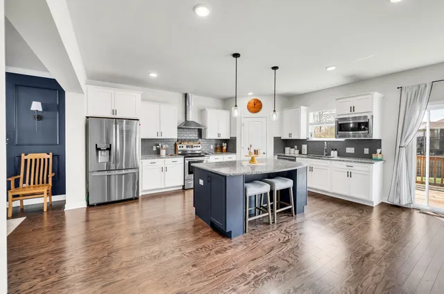 a kitchen with kitchen island granite countertop stainless steel appliances refrigerator oven stove microwave and cabinets