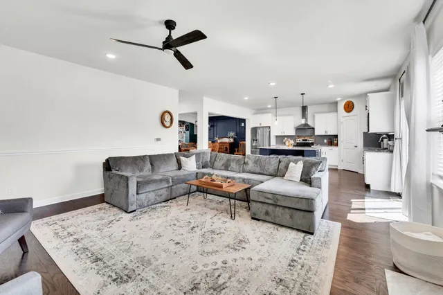 a living room with furniture and a ceiling fan